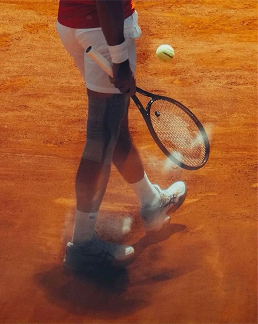 Гравець з ракеткою на ґрунтовому корті